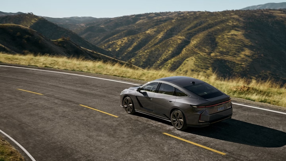 A gray 2026 Lexus ES sedan driving down a mountain road