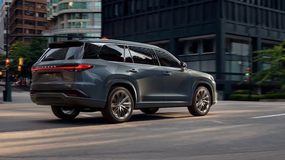 A gray 2026 Lexus TX luxury SUV driving down a city street