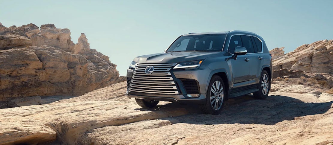 A gray Lexus LX Hybrid parked on a rocky ledge